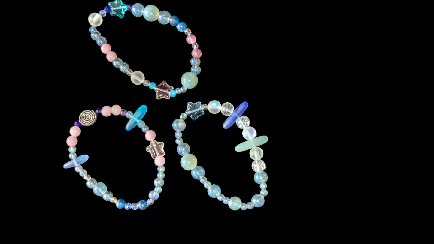 Three beaded bracelets on a textured black surface